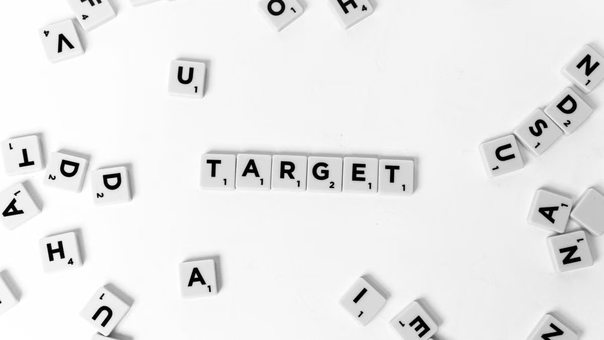 A collection of Scrabble tiles arranged to spell 'Target' among scattered letters on white background.